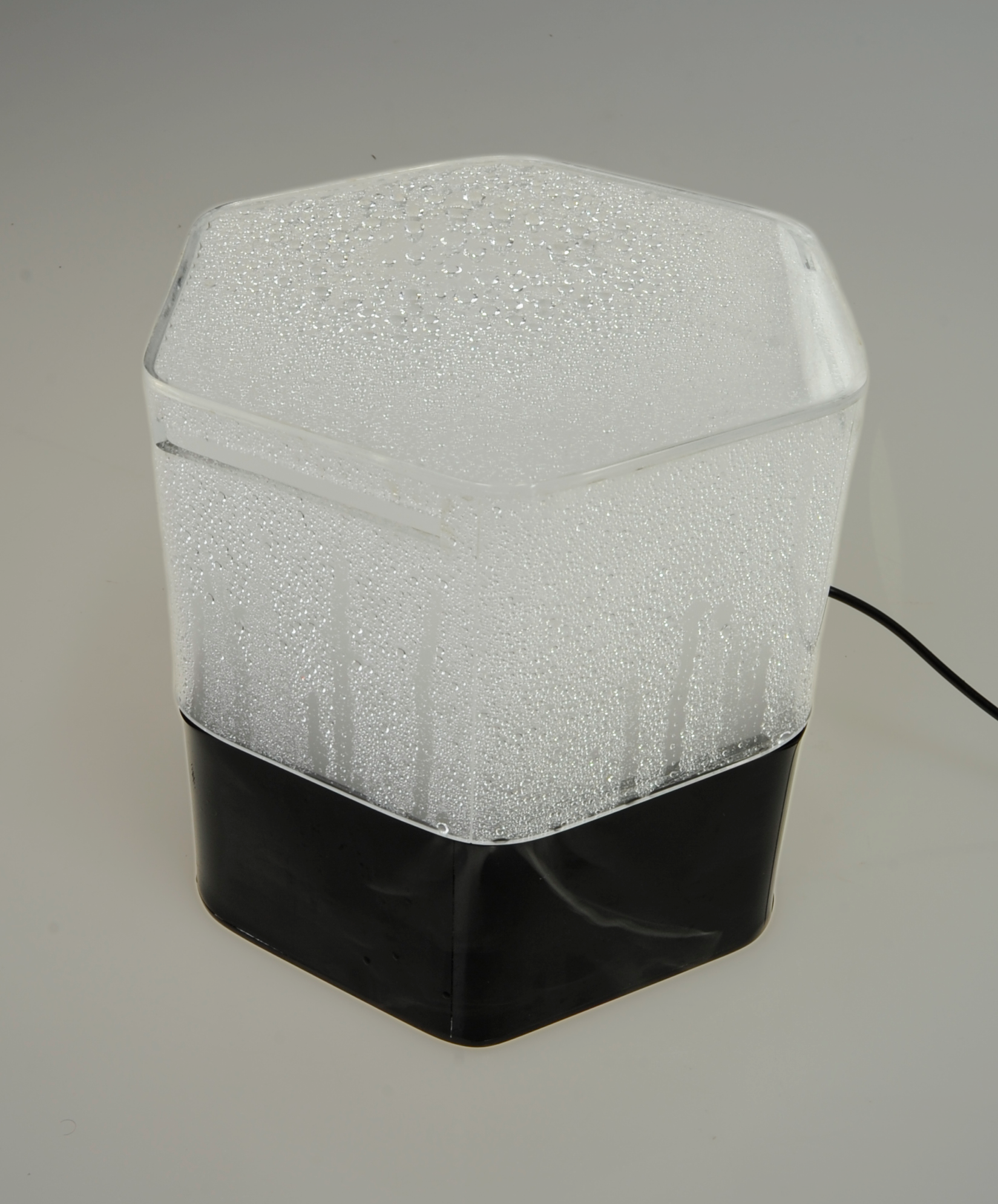 Photo of Aura, a hexagonal mood tempescope, on its rainy setting, amidst a plain white background.